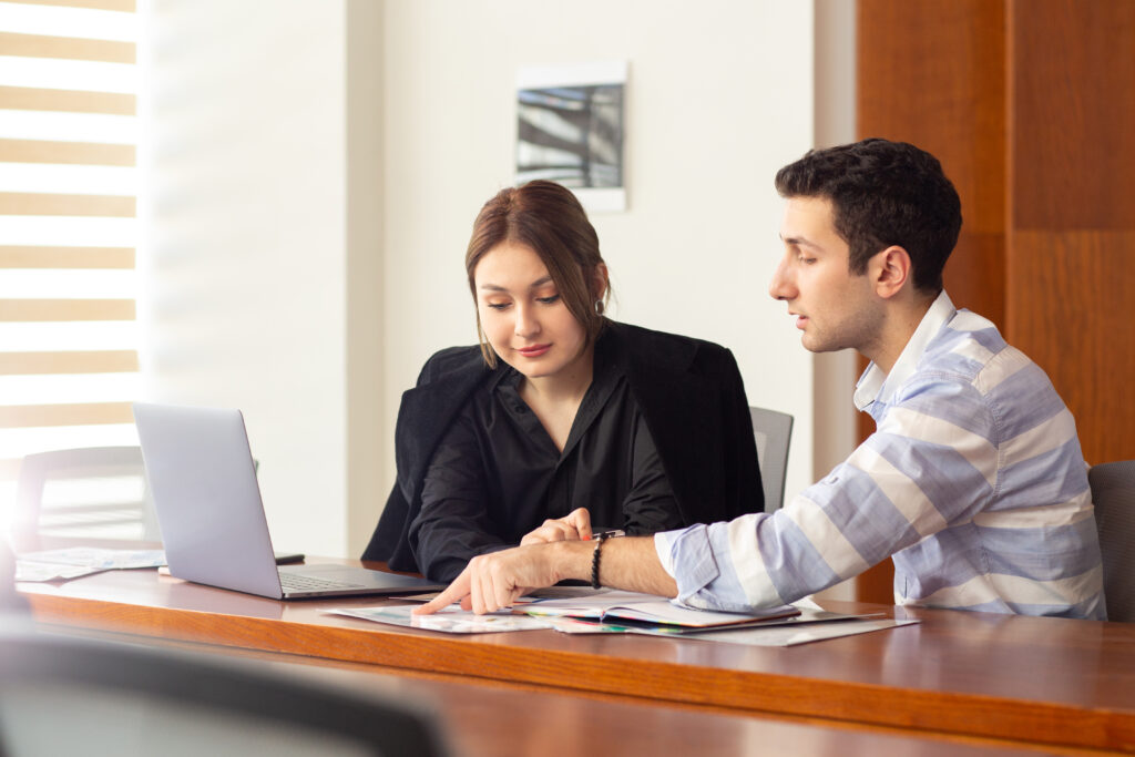front view young beautiful businesswoman black shirt black jacket along with young man discussing work issues inside her office work job building